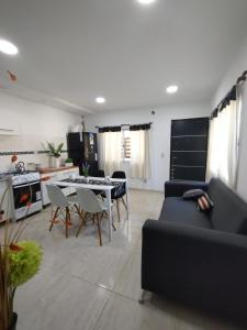 a kitchen and a living room with a table and chairs at El Temple Timperio in San Clemente del Tuyú