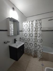 a bathroom with a sink and a shower curtain at El Temple Timperio in San Clemente del Tuyú