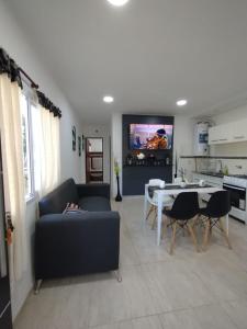 a living room with a couch and a table and a tv at El Temple in San Clemente del Tuyú