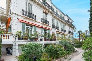 a building with potted plants on the side of it at Pavillon d'Angleterre au cœur de la ville in Menton