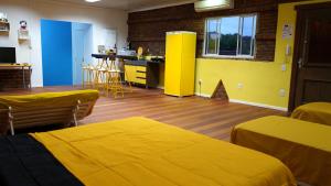 Pokój z 2 łóżkami i kuchnią z żółtymi ścianami w obiekcie LOFT AMARELO temático prox ao Shopping Bourbon Ipiranga w mieście Porto Alegre