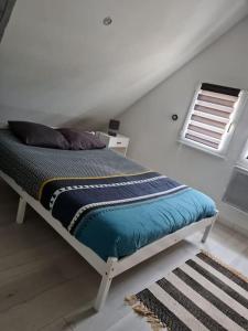 uma cama num quarto branco com uma janela em L'atelier Abbevillois by H2C em Abbeville