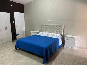 a bedroom with a large bed with a blue blanket at Depto XL Villa Unión in Villa Unión