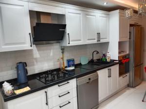 eine Küche mit weißen Schränken und einem Waschbecken in der Unterkunft Boztepe residence in Trabzon