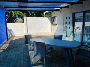 een blauwe tafel en stoelen op een patio bij The Starfish Cottage in Scottburgh