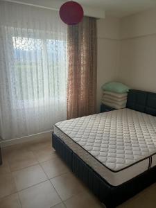 Bett in einem Zimmer mit einem Fenster mit einer Matratze in der Unterkunft QUEENABA SiTESi in Erdemli