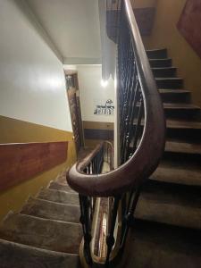 una escalera de caracol en un edificio con barandilla de madera en Hostal Andrea, en Madrid
