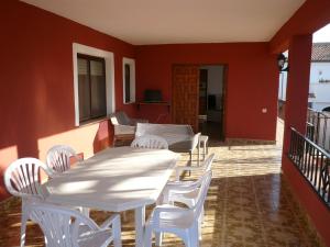 a patio with white tables and white chairs at CASA INOCENCIA in Alcossebre