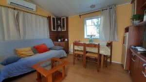 uma sala de estar com um sofá azul e uma mesa em Mobil home camping les écureuils em Mimizan