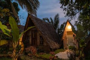 Una casa con una luz en el costado. en Sumatra Thomas Leaf Monkey Guesthouse & Jungle Trek en Bukit Lawang