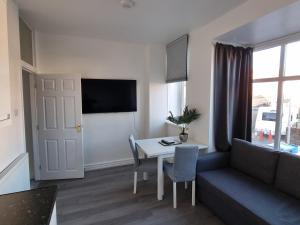 uma sala de estar com um sofá e uma mesa em Granada Apartments Queen's Promenade em Blackpool