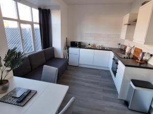 a kitchen and living room with a couch and a table at Granada Apartments Queen's Promenade in Blackpool
