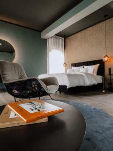 een slaapkamer met een bed, een stoel en een tafel bij Hotel Atlantic in Westerland