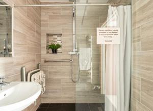 a bathroom with a sink and a shower with a shower curtain at Razak House in Brighton & Hove