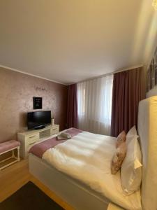 een hotelkamer met een bed en een televisie bij Vila CCC in Oradea
