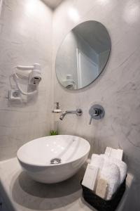 y baño con lavabo blanco y espejo. en Kamara Sea View Villa en Kamari
