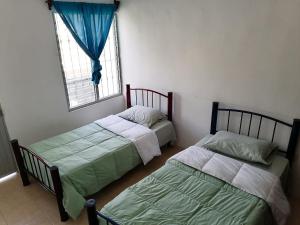 2 camas en una habitación con ventana en Casa D vacaciones/negocios/WiFi/CableTV/2Estaciona, en Tuxtla Gutiérrez