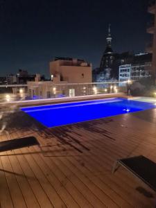 a blue swimming pool on the roof of a building at night at Paseo De La Cisterna UF 320 in Buenos Aires