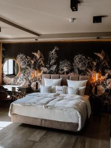 a bedroom with a large bed and a wall with plants at Hotel Atlantic in Westerland (Sylt)