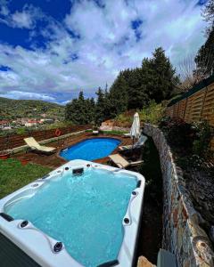 eine Badewanne neben einem Pool in der Unterkunft Ampelos Cretan Villa - Private Pool & Heated Ozone Jacuzzi in Yerolákkos