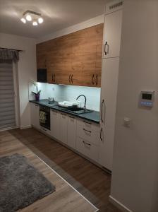 a kitchen with white cabinets and a sink at Apartament Zielone Tarasy in Rzeszów