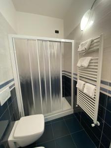 a bathroom with a shower and a toilet and towels at Sandra Villa Rooms in Corniglia +27 photos