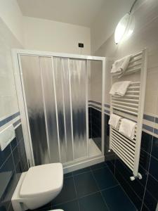a bathroom with a shower and a toilet and towels at Sandra Villa Rooms in Corniglia