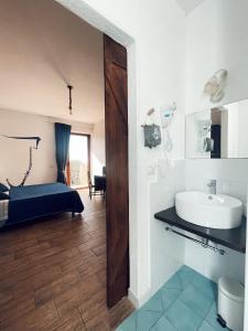 łazienka z umywalką i łóżkiem w pokoju w obiekcie Residenza Cunto w mieście Castellabate