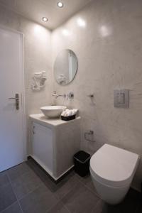 y baño con lavabo, aseo y espejo. en Kamara Sea View Villa, en Kamari