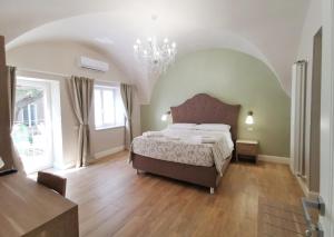 a bedroom with a bed and a chandelier at Opera Relais 85 in Messina
