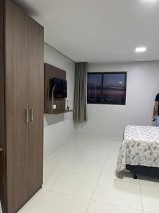 1 dormitorio con 1 cama y TV de pantalla plana en Excelente Apartamento mobiliado em Campina Grande, en Campina Grande