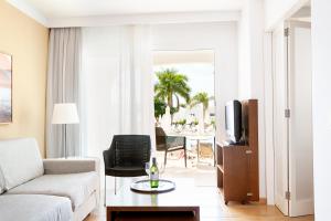 een woonkamer met een bank en een tv bij Sunprime Atlantic View Suite & Spa in Playa del Inglés