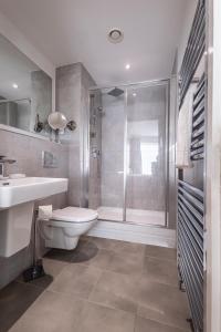 a bathroom with a shower and a toilet and a sink at Seaview West Coast - Exceptional - 2 Bedrooms Sleeps 5 -Stunning Sea Views - 500 metres to Beach in Bournemouth +48 photos