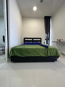 ein Schlafzimmer mit einem Bett mit einer grünen Bettdecke in der Unterkunft Sea View The Shore Luxury Newly Renovated Homestay in Kota Kinabalu