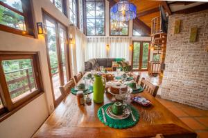 uma sala de jantar com uma mesa de madeira numa casa em Casa das Pedras em Monte Verde