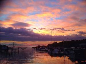 una puesta de sol sobre un puerto con barcos en el agua en Il glicine Marina Romea, en Marina Romea