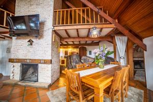 ein Wohnzimmer mit einem Holztisch und einem Kamin in der Unterkunft Casa das Pedras in Monte Verde