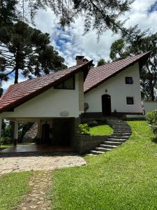 a white house with a pathway leading to it at Casa das Pedras in Monte Verde