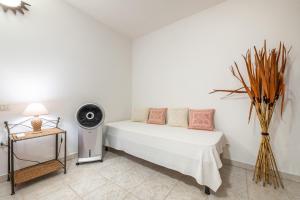 a bedroom with a bed with a fan and a table at Villa Lilla in Villasimius