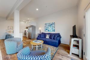 a living room with a blue couch and chairs at Penn Cove Strand #F in Coupeville