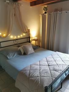 ein Schlafzimmer mit einem großen Bett mit Beleuchtung in der Unterkunft LES PAPILLONS in Flassans-sur-Issole