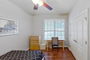 a bedroom with a bed and a desk and a ceiling fan at Tucumcari Treat in Austin