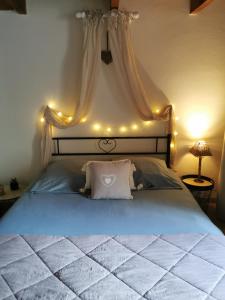 ein Schlafzimmer mit einem Bett mit Beleuchtung in der Unterkunft LES PAPILLONS in Flassans-sur-Issole