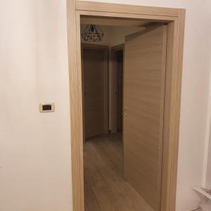 ナポリにあるMERGELLINA APARTMENTの廊下のある部屋へとつながる木製のドア