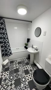 a bathroom with a sink and a toilet and a tub at Waterfront town centre ipswich apartment in Ipswich