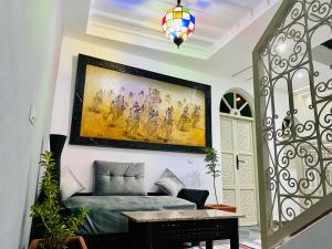 a living room with a couch and a painting on the wall at DAR Riad Jomana in Marrakech
