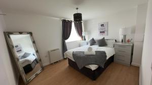 a bedroom with a large bed and a mirror at Waterfront town centre ipswich apartment in Ipswich