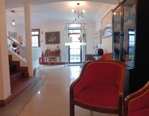 a living room with a red chair and a staircase at Hotel Insular in Ponta Delgada