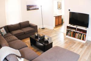 a living room with a couch and a flat screen tv at 2 BR - Off Street Parking - Amazing View Nearby in Pittsburgh