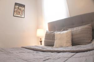 a bedroom with a bed with pillows on it at 2 BR - Off Street Parking - Amazing View Nearby in Pittsburgh